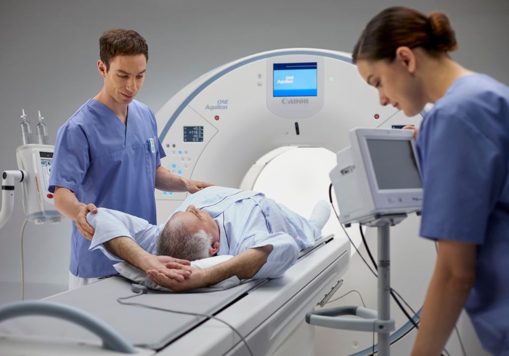 man in luxury health facility entering an MRI machine with the help of health professionals