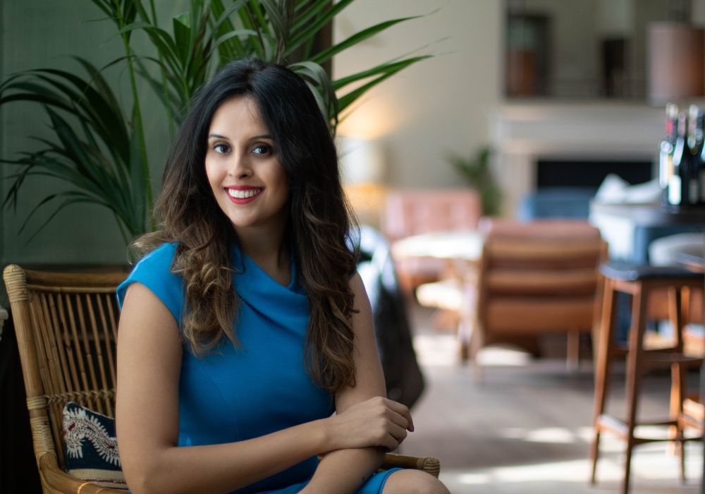 woman sat in luxury restaurant with a smile on her face