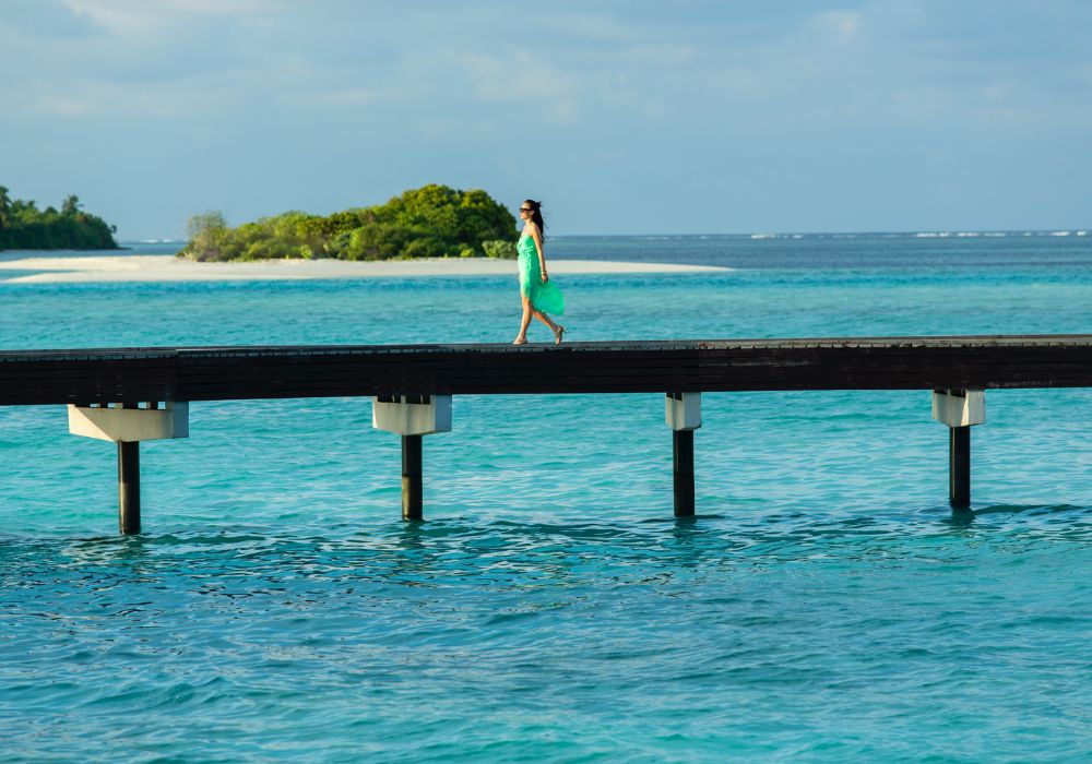 Woman walking through luxury hotel resort in Maldives