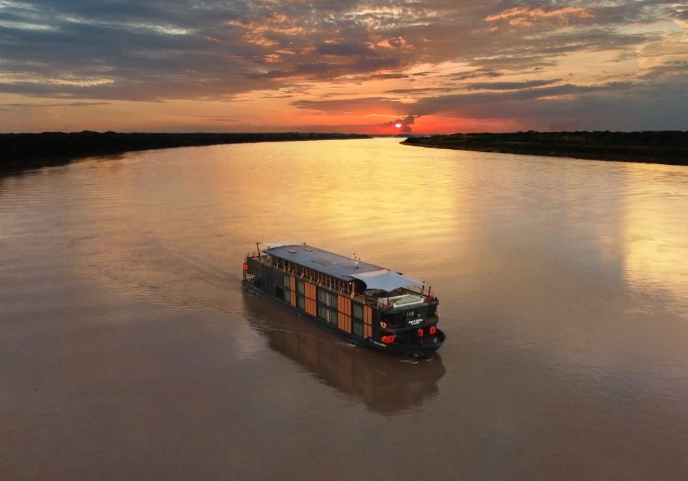 sun set over large river with luxury ship luxury travel lifestyle pr