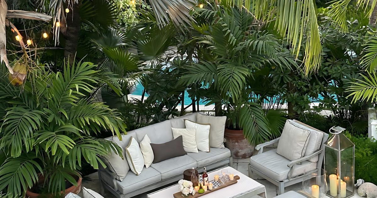 A cozy outdoor living space nestled among lush tropical greenery, complete with comfortable seating, ambient lighting, and a calming, natural atmosphere.