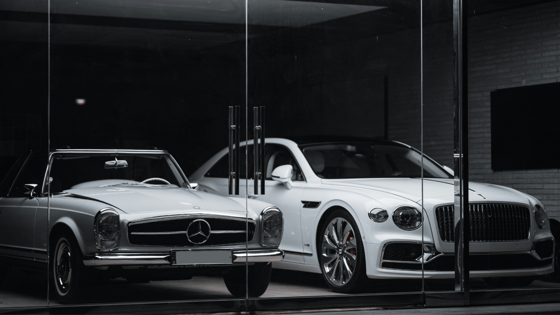 A classic and modern luxury side by side: vintage mercedes convertible meets contemporary bentley sedan in a sleek showroom.
